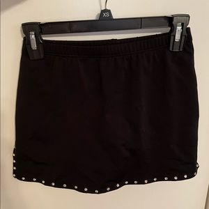 Motionwear black skort with slits on the sides and silver rhinestone trim.